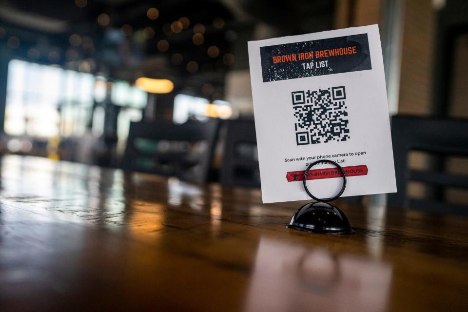 A QR code-activated menu on a table at Brown Iron Brewhouse on April 7, 2021, in Royal Oak, Mich. The restaurant implemented the practices in order to cut down on high touch serves, but still offers traditional menus upon request.