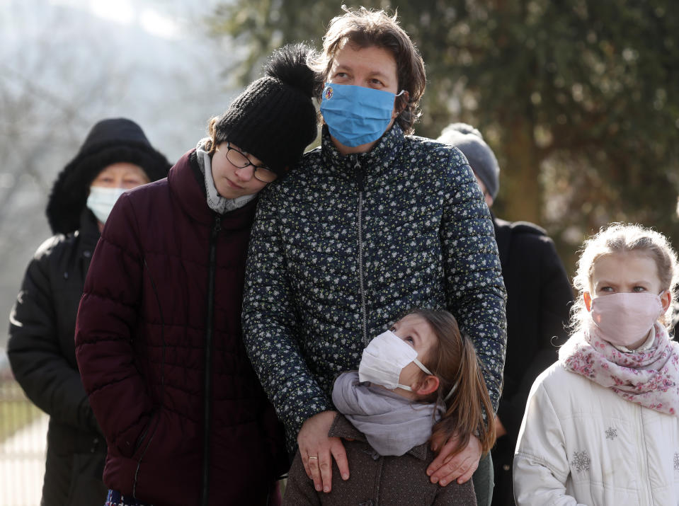 People, wearing masks for protection against the COVID-19 infection, stand outdoors during an outdoor Lutheran Church religious service in Csovar, Hungary, Sunday, Jan. 24, 2021. While Hungary has imposed strict COVID-19 restrictions, including a ban on gatherings of more than 10 people, the government has not limited religious events. The Catholic Church, which represents a majority of Hungarian Christians, holds its masses almost as it did in pre-pandemic times, but other religious communities have sought other solutions to limit exposure to the virus. (AP Photo/Laszlo Balogh)