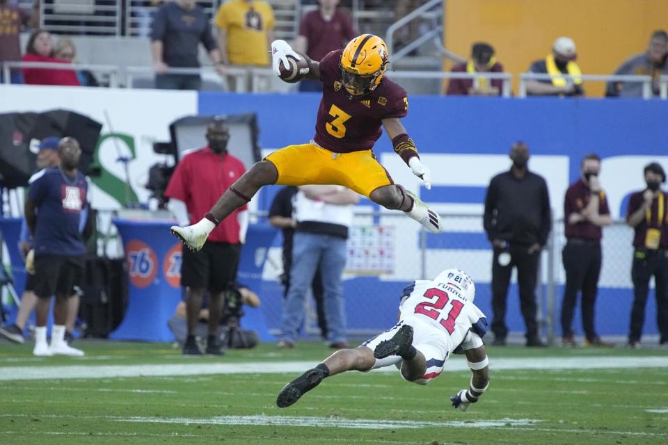 Arizona State running back Rachaad White leaps over Arizona safety Jaxen Turner during a game in November 2021.