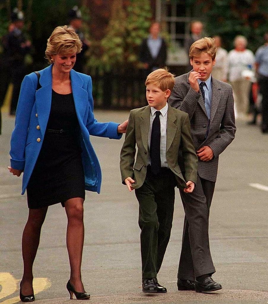 The young princes dressed in suits and ties walking with their mother