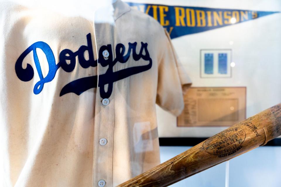 A Jackie Robinson's Brooklyn Dodgers uniform and bat on display at the Jackie Robinson Museum.