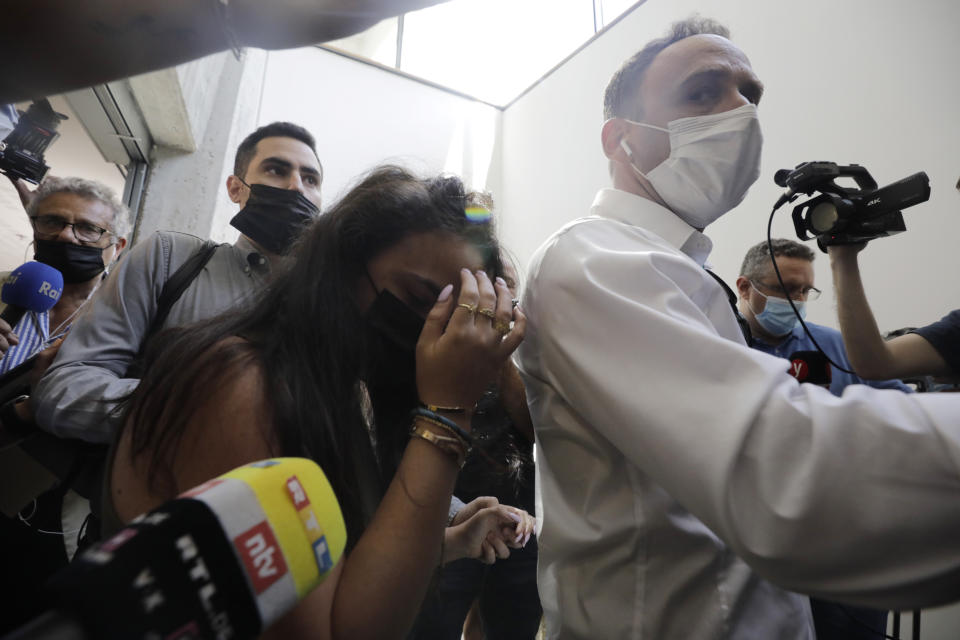 Gali Peleg, center, maternal aunt of Eitan Biran, who survived a cable car crash in Italy that killed his immediate family, leaves court in Tel Aviv on Thursday, Sept. 23, 2021 after a hearing in the alleged kidnapping of her nephew. The boy's parents and younger sibling were among 14 killed in May when a cable car slammed into a mountainside in northern Italy. He is now the focus of a custody battle between his maternal grandparents in Israel and his paternal relatives in Italy. (AP Photo/Sebastian Scheiner)