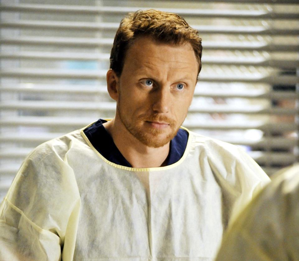Owen Hunt from Grey's Anatomy in scrubs, looking concerned in a hospital setting
