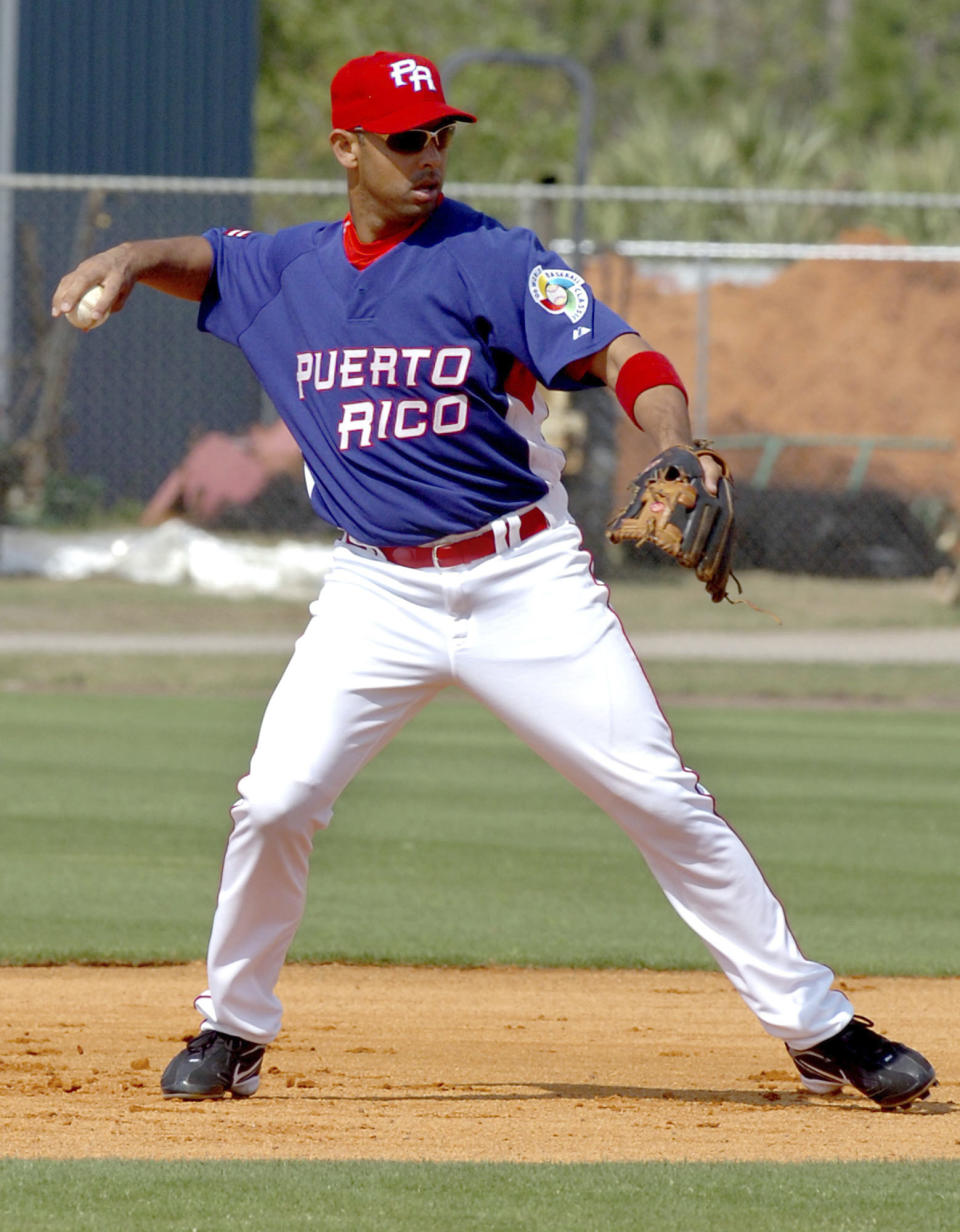 FILE - In this March 4, 2006 file photo Alex Cora, of Puerto Rico, throws to first during a workout for the World Baseball Classic in Port St. Lucie, Fla. Cora spent this season rewarding the support of Jackie Bradley Jr., David Price and the rest of the Boston Red Sox organization with a record-breaking year and a run deep into the playoffs. The rookie manager's accomplishments go further than the baseball diamond, too. Having seen his homeland of Puerto Rico devastated by Hurricane Maria, Cora remains at the forefront of helping the island rebuild. (AP Photo/Rick Silva, file)