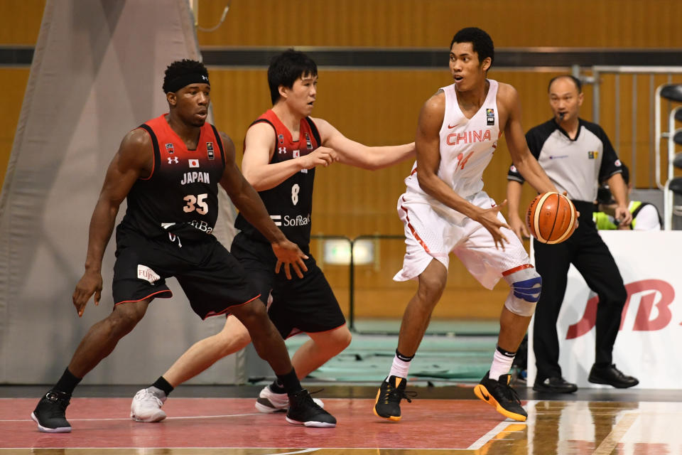 Jianiyou Taruike #14 of China handles the ball under pressure from Atsuya Ota #8 during the third place playoff match between Japan and China (Photo by Takashi Aoyama/Getty Images)