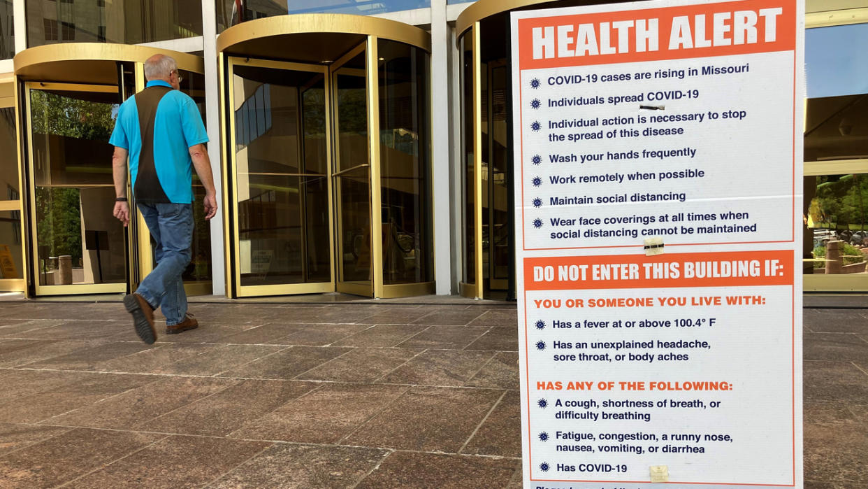 A sign warning of COVID-19 dangers remains in place Tuesday, June 15, 2021, outside the entryway of a state office building in Jefferson City, Mo. (David A. Lieb/AP Photo)
