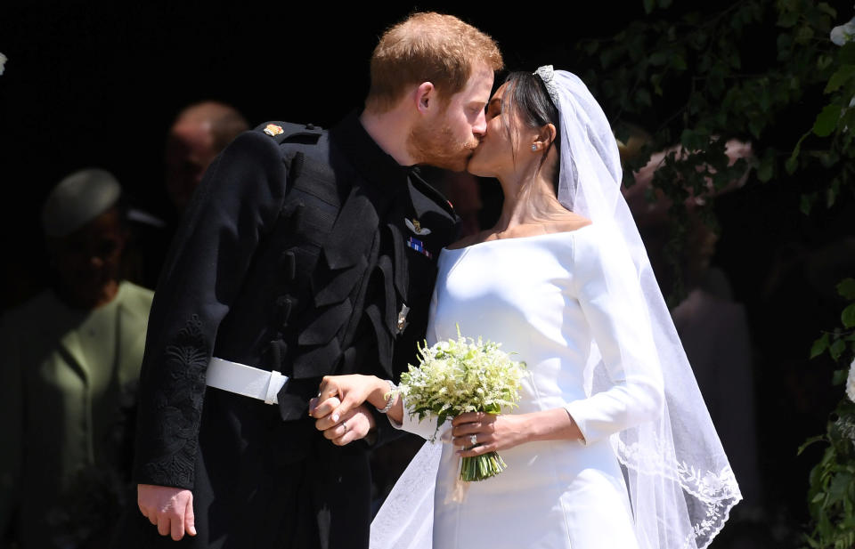 Britain’s Prince Harry, Duke of Sussex and Meghan, Duchess of Sussex kiss as they exit St George’s Chapel in Windsor Castle. Source: NEIL HALL/Pool via REUTERS