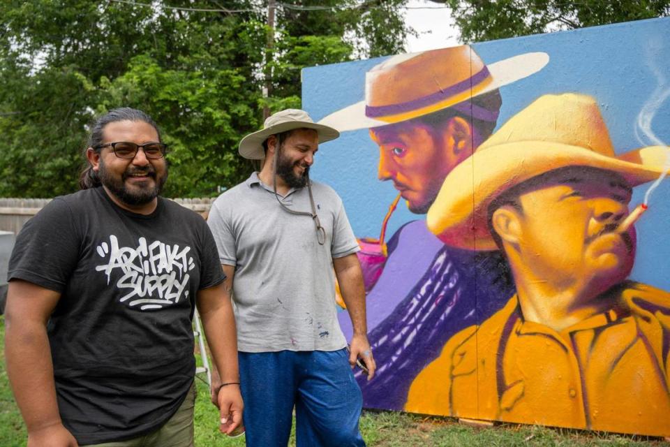 Muralists Rodrigo “Rico” Alvarez, right, and Isaac Tapia take a break from working on a scaled down version of a mural in Tapia’s backyard. The artists take photos of their practice designs and then reference the work from their smartphones while they paint the final version. Emily Curiel/ecuriel@kcstar.com