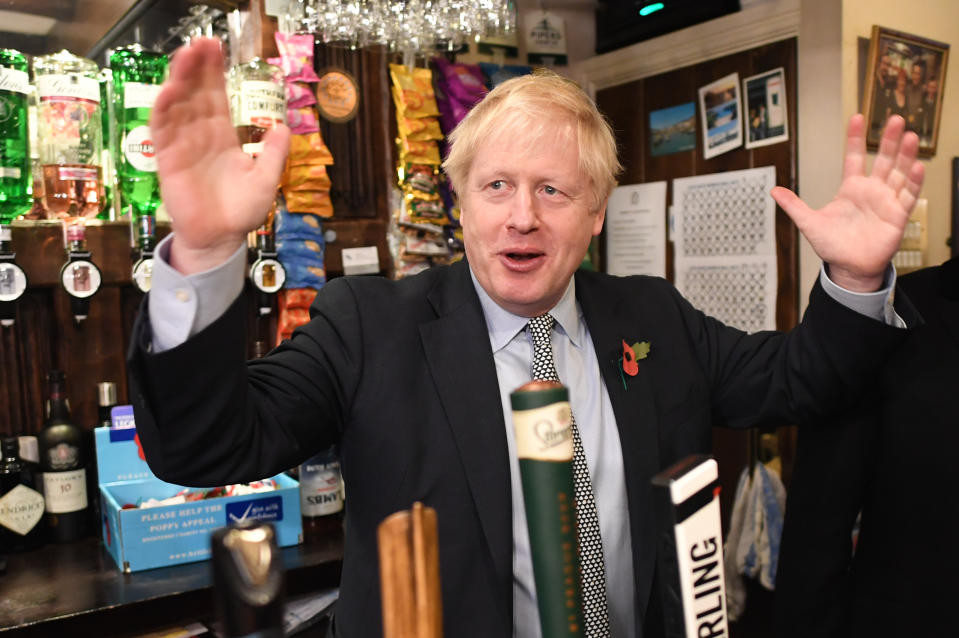 Prime Minister Boris Johnson, steps behind the bar to pull a pint as he meets with military veterans at the Lych Gate Tavern in Wolverhampton. (Photo by Stefan Rousseau/PA Images via Getty Images)