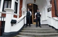 Metropolitan Police Officers wait outside the main door of the Ecuadorian embassy in London. Ecuador said it will announce its decision on granting asylum to WikiLeaks founder Julian Assange on Thursday, setting up a showdown with Britain, which vowed to extradite him to Sweden