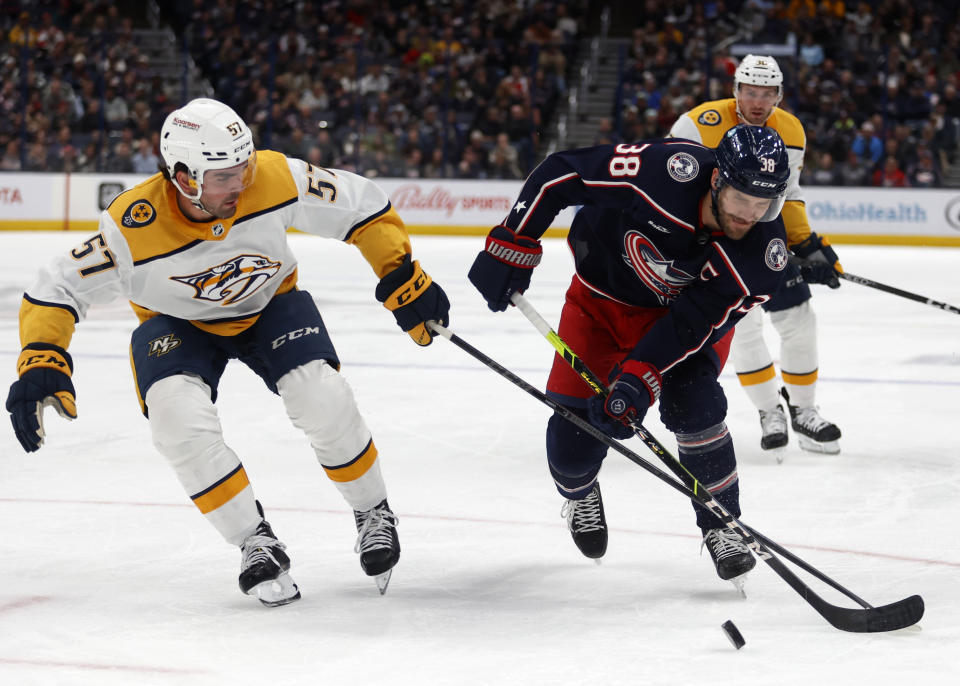 Columbus Blue Jackets forward Boone Jenner right, works for the puck against Nashville Predators defenseman Dante Fabbro during the second period of an NHL hockey game in Columbus, Ohio, Thursday, Oct. 20, 2022. (AP Photo/Paul Vernon)