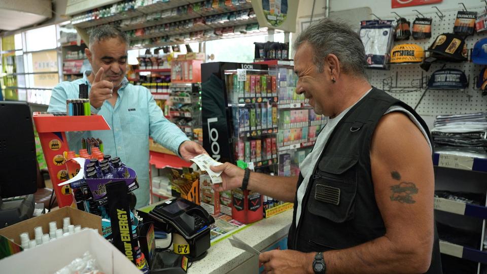 Vinnie Clemente, right, buys Powerball tickets from Elias Harv at a gas station, on Friday, July 14, 2023, in Crystal, Minnesota.