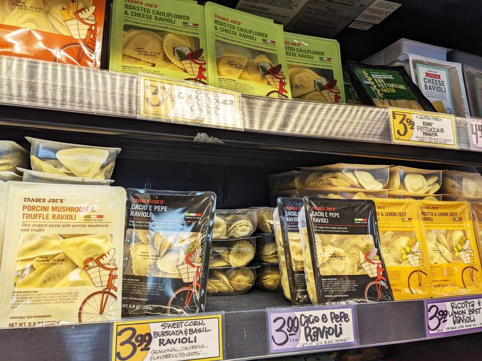 Cacio e pepe ravioli on a shelf at Trader Joe's surrounded by other types of ravioli.