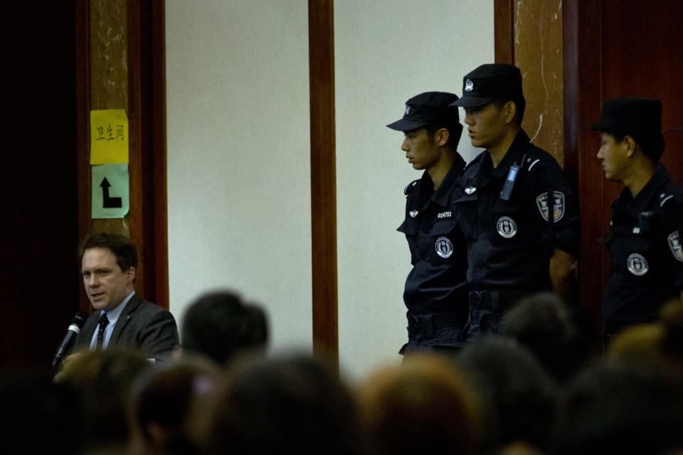 Policemen guard their positions near a translator, left, during a meeting between Malaysian officials and relatives of Chinese passengers onboard the missing Malaysia Airlines Flight 370 at a hotel in Beijing, China, Wednesday, April 30, 2014. The Australian agency heading up the search for the missing Malaysian jet has dismissed a claim by a resource survey company that it found possible plane wreckage in the northern Bay of Bengal. (AP Photo/Alexander F. Yuan)