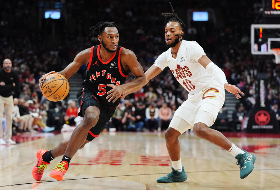 Toronto Raptors guard Immanuel Quickley (5) drives past Cleveland Cavaliers guard Darius Garland (10 during the first half of an NBA basketball game, Saturday, Feb. 10, 2024 in Toronto. (Frank Gunn/The Canadian Press via AP)