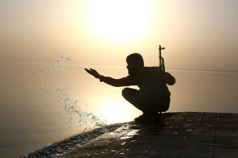 A member of the US-backed Syrian Democratic Forces splashes water at Lake Assad on April 29, 2017