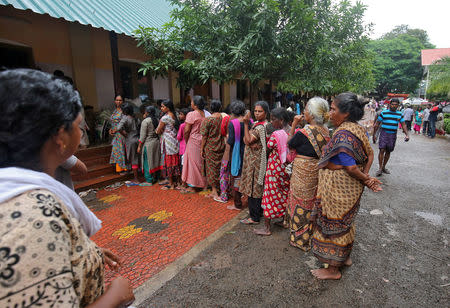 Flood-affected women wait in a queue to receive relief material at a camp in Chengannur in the southern Indian state of Kerala, India, August 20, 2018. REUTERS/Amit Dave