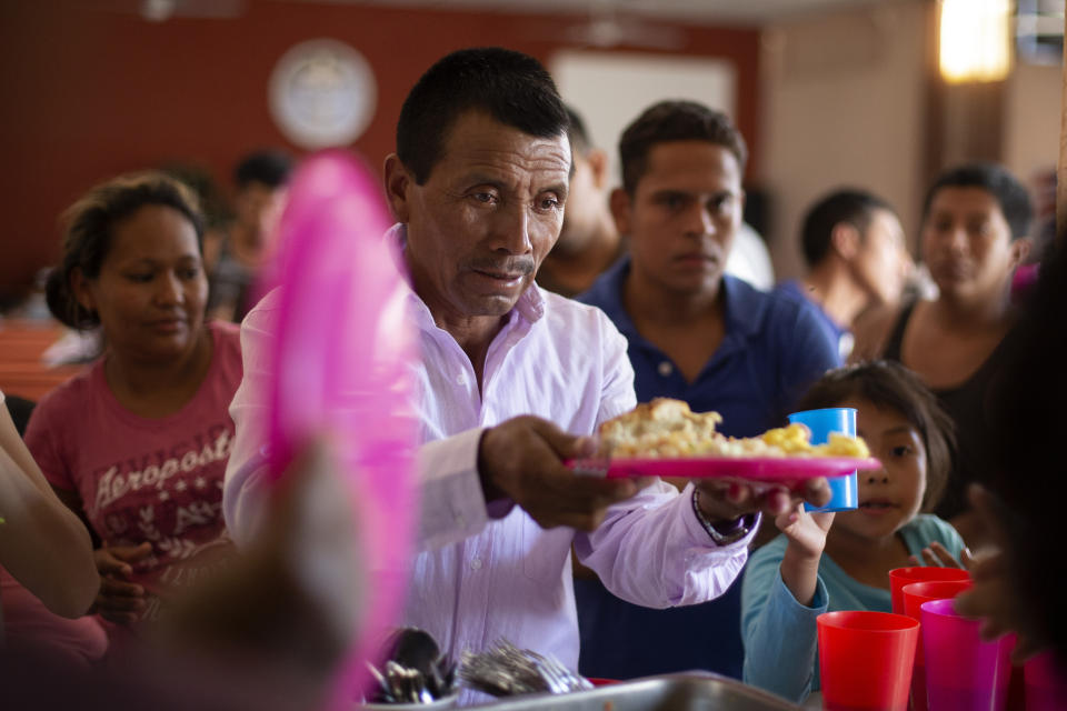 In this July 25, 2019, photo, a Guatemalan man gets a plate of food at El Buen Pastor shelter for migrants in Cuidad Juarez, Mexico. (AP Photo/Gregory Bull)