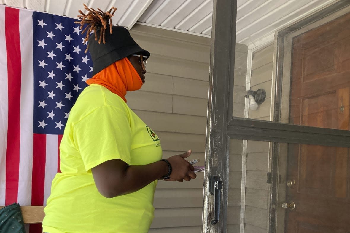 Erika Hardwick waits at a door on Wednesday, Oct. 5, 2022 in Dawson, Ga., as she canvasses for the New Georgia Project Action Fund. (AP Photo/Jeff Amy)