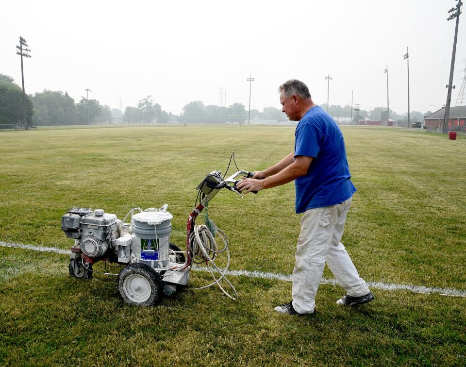 Ernie Sellers of Monroe Public Schools finishes painting the football field yard lines Thursday morning at Navarre Field in Monroe for the Southeast Michigan Red Storm semi-professional game Saturday. Due to the poor air quality from wildfire smoke from Canada that covered Michigan in a haze this past week, the Monroe football camp for youth in third through seventh grades was canceled Wednesday but will be rescheduled.