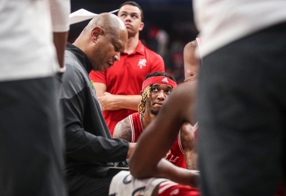 A disappointed senior Louisville guard El Ellis listens as head coach Kenny Payne talks about a play late in the second half where Louisville lost 71-54 to Virginia Tech Tuesday night at the KFC Yum Center. The Cards finished 4-26 overall, 2-17 in the ACC. Feb. 28, 2023
