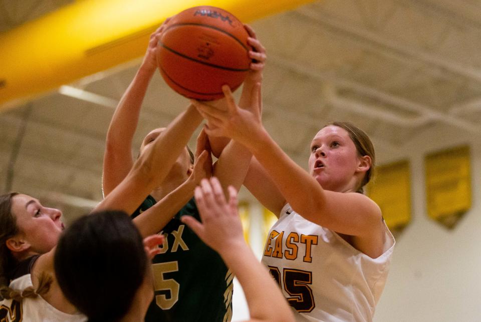 East's Emily Wierenga (right) looks to grab a rebound during a game between Zeeland East and West Friday, Jan. 6, 2023, at Zeeland East High School. 