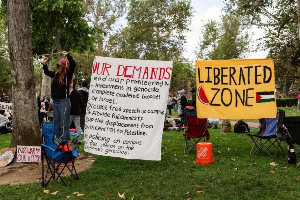 A protester hangs up banners as the “Gaza Solidarity Occupation” begins at the University of Southern California on April 24.<span class="copyright">Marissa Ding for Daily Trojan</span>