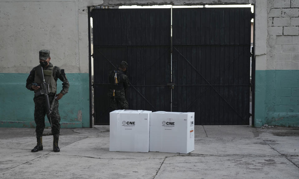 Soldiers guard boxes of electoral ballots after the closing of a voting center during general elections in Tegucigalpa, Honduras, Sunday, Nov. 28, 2021. The National Electoral Council called on political parties to refrain from declaring their candidates victorious or providing partial vote totals while voting was ongoing. (AP Photo/Moises Castillo)