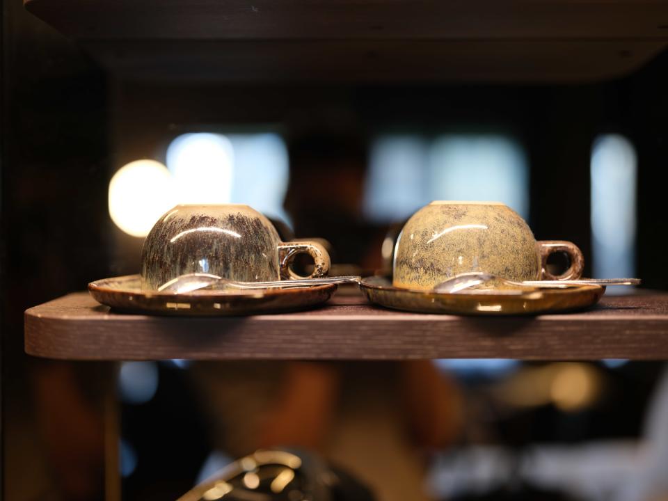 Two coffee mugs on a shelf