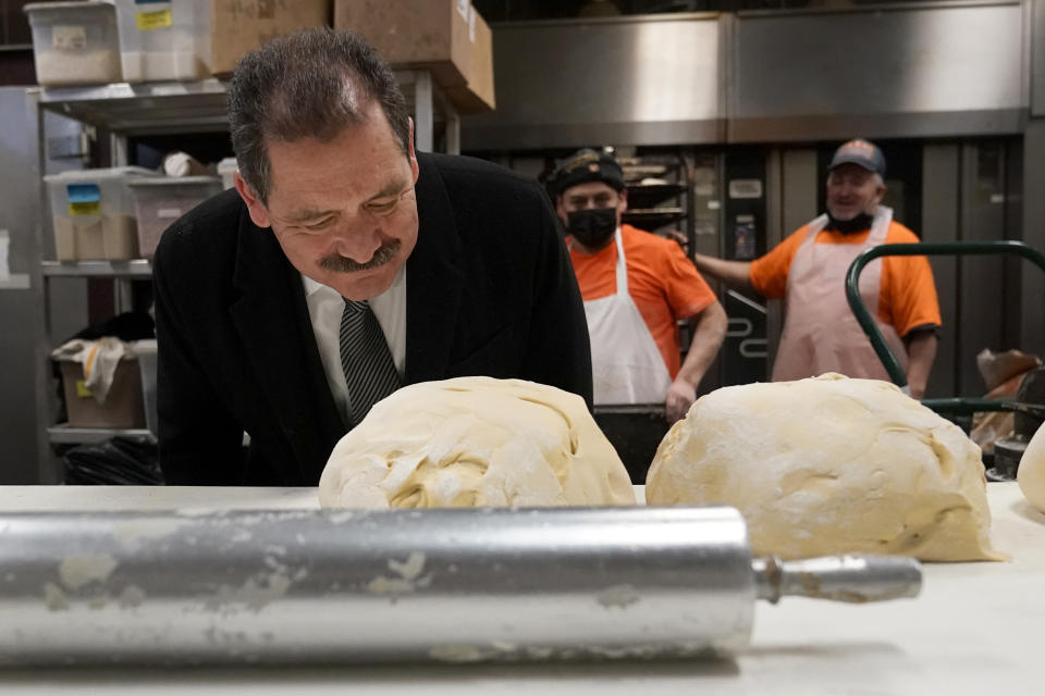 Chicago mayoral candidate Rep., Jesus "Chuy" Garcia, D-Ill., bends over to smell the fresh bread dough during a campaign stop at the Morelia Supermarket bakery Wednesday, Feb. 22, 2023, in Chicago. Garcia, who continues to seek the mayor's office, forced then-Mayor Rahm Emanuel to a runoff in 2015. (AP Photo/Charles Rex Arbogast)
