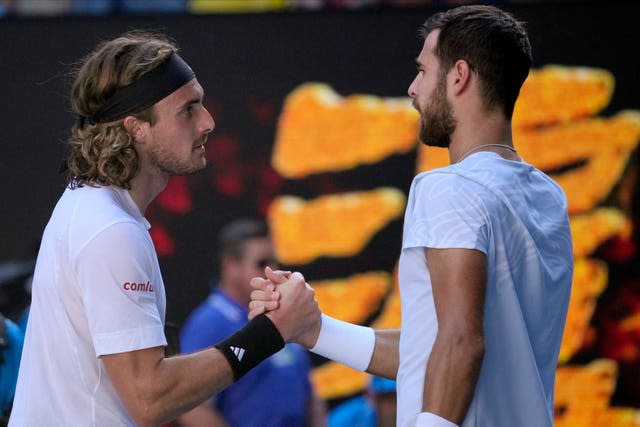 Stefanos Tsitsipas, left, shakes hands with Karen Khachanov