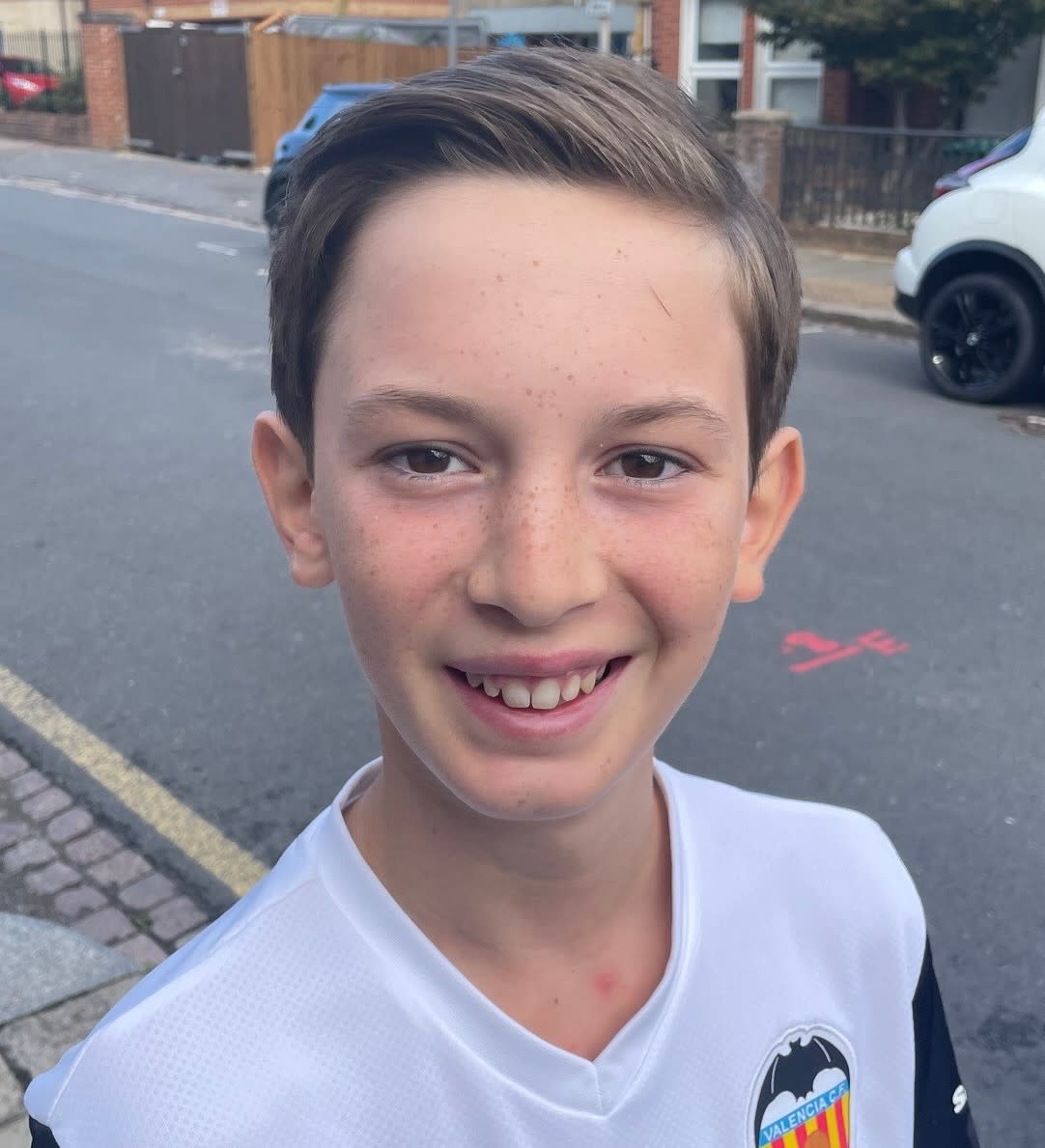 Boy wearing white t-shirt and smiling at the camera