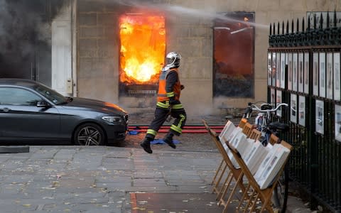 A firefighter runs as he works to put out a fire in "La Hune" book shop in the Saint-Germain-des-Pres district Paris on November 16 - Credit: AFP