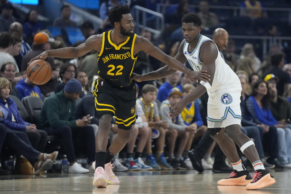 Golden State Warriors forward Andrew Wiggins (22) looks to pass while defended by Minnesota Timberwolves guard Anthony Edwards during the first half of an NBA basketball game in San Francisco, Sunday, Nov. 12, 2023. (AP Photo/Jeff Chiu)