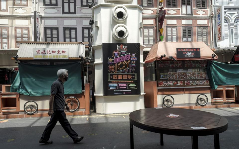 A man walks past closed food stalls in the historic Chinatown district in Singapore amid Phase 2 (Heightened Alert) coronavirus restrictions - WALLACE WOON/EPA-EFE/Shutterstock