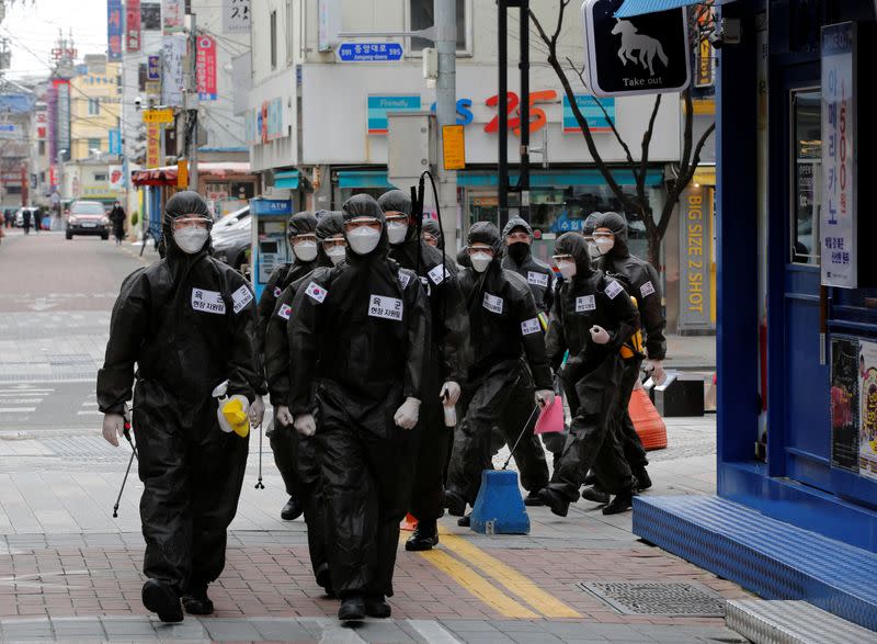 South Korean soldiers in protective gear make their way while they disinfect buildings downtown, following the rise in confirmed cases of coronavirus disease (COVID-19) in Daegu