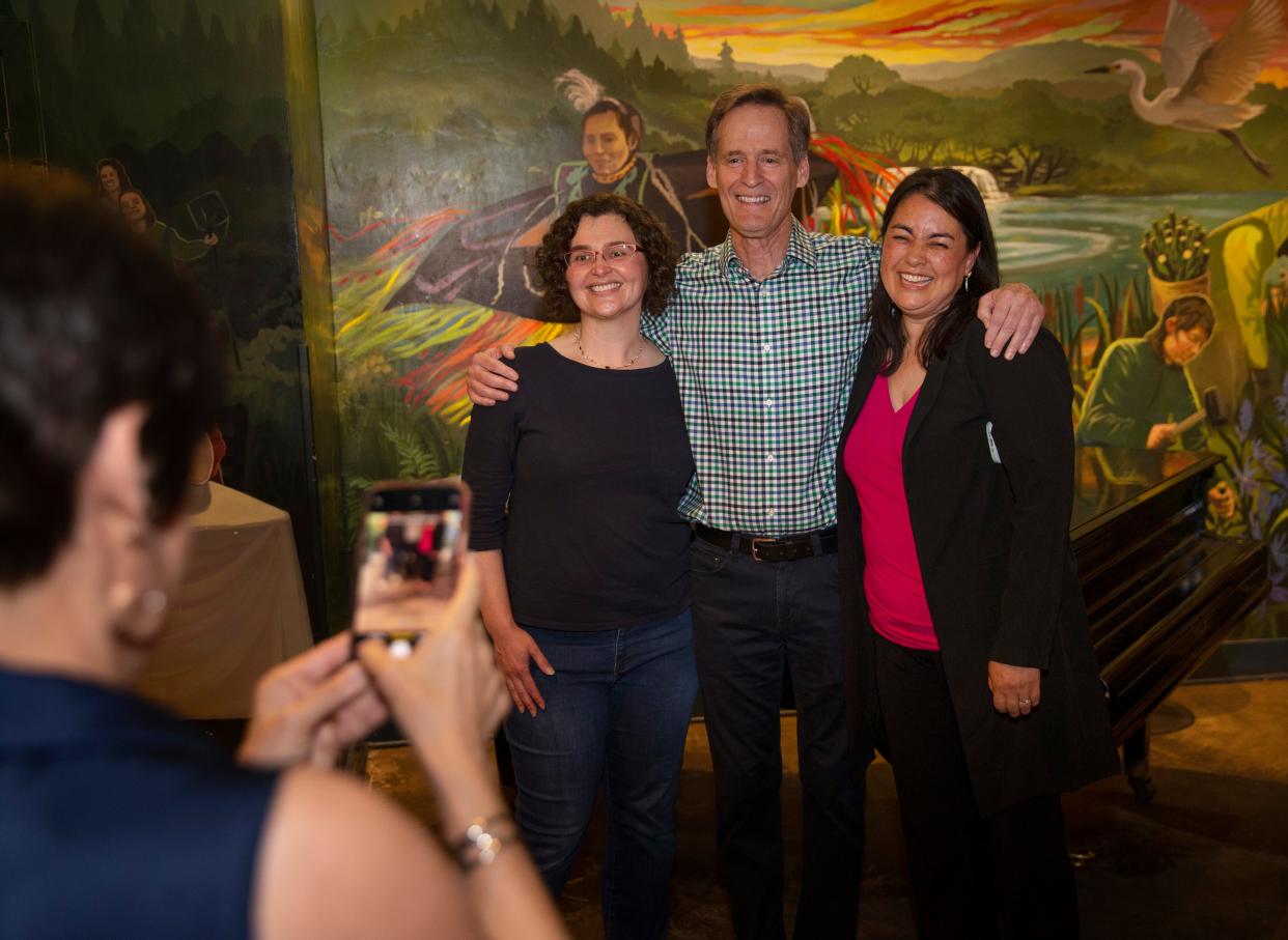 Jacquelyn Lane, left, takes a photo of Eugene 4J school board candidates Morgan Munro, Tom Di Liberto and Jenny Jonak during an election watch party at Whirled Pies.