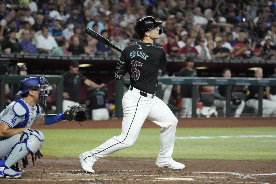 Arizona Diamondbacks' Randal Grichuk, right, watches the flight of his three-run home run as Los Angeles Dodgers catcher Austin Barnes, left, looks on during the second inning of a baseball game Sunday, Sept. 1, 2024, in Phoenix. (AP Photo/Ross D. Franklin)