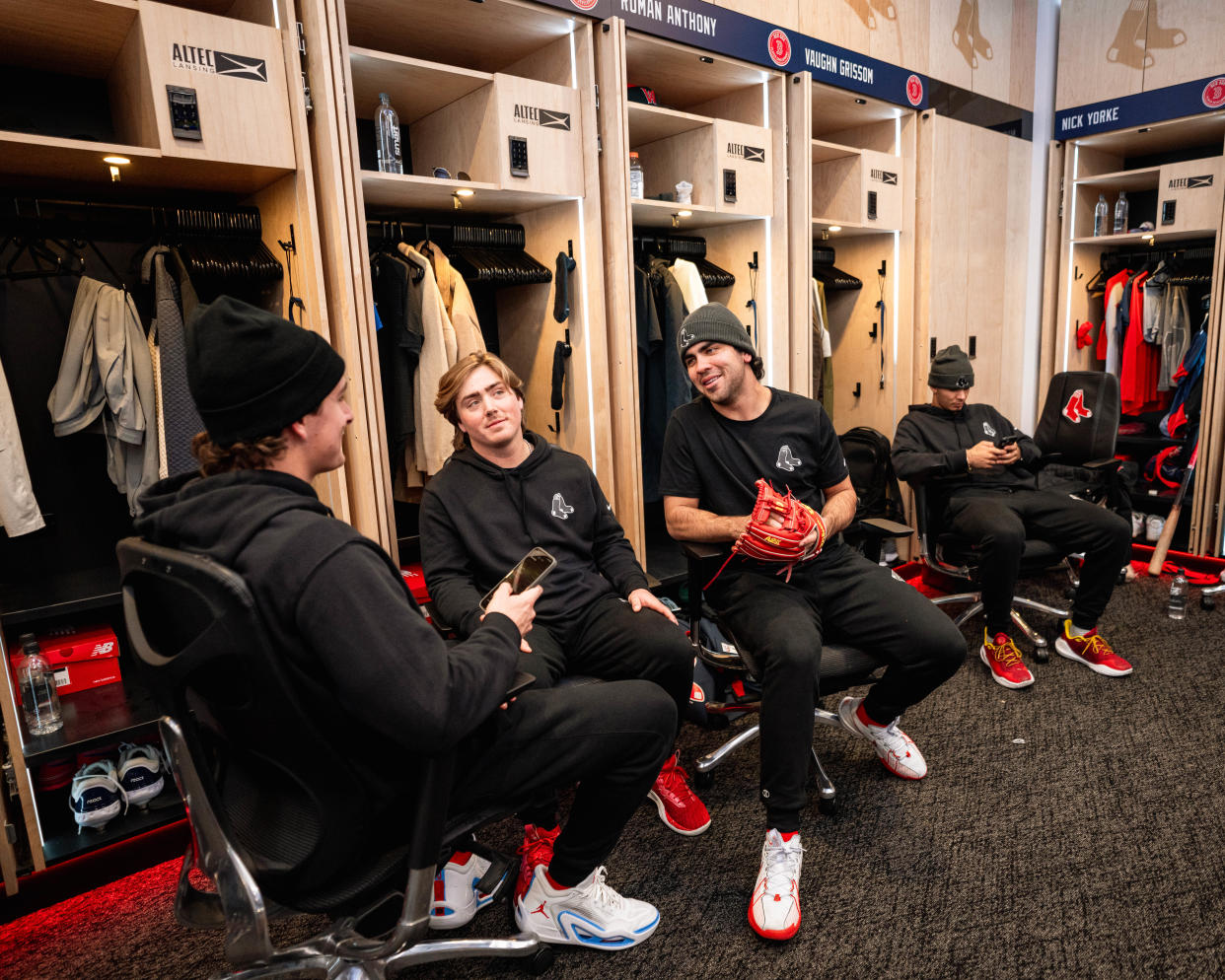 A few of the Boston Red Sox's top prospects, from left, Roman Anthony, Nathan Hickey and Marcelo Mayer talk inside the Red Sox clubhouse at Fenway Park as part of the Red Sox Development Program in mid-January.