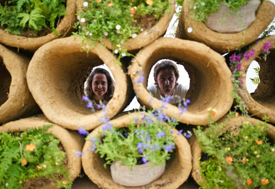 Designers Finbar Ward and Tilly Dallas look through bee hives formed from cylinders of clay, as part of RHS Chelsea Flower Show (Yui Mok/PA) (PA Wire)