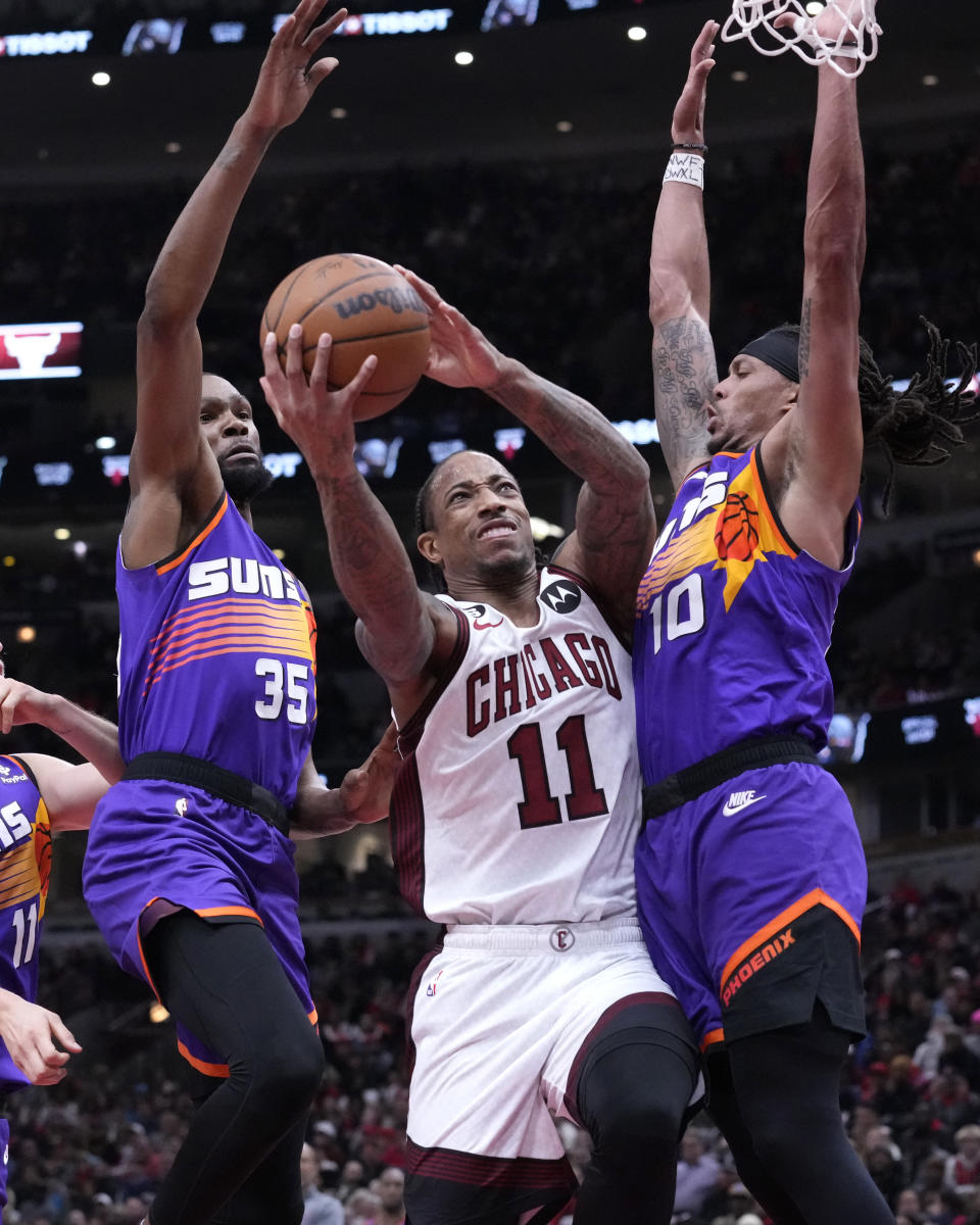 Chicago Bulls' DeMar DeRozan (11) drives to the basket between Phoenix Suns' Kevin Durant (35) and Damion Lee during the second half of an NBA basketball game Friday, March 3, 2023, in Chicago. (AP Photo/Charles Rex Arbogast)