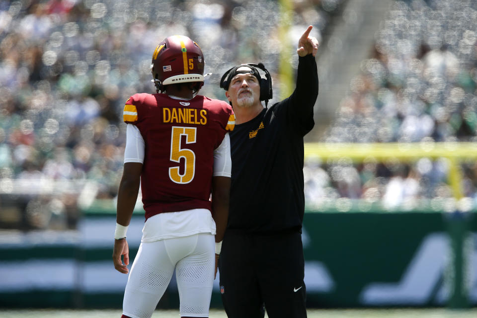 Washington Commanders head coach Dan Quinn talks with quarterback Jayden Daniels (5) during the first half of an NFL preseason football game against the New York Jets Saturday, Aug. 10, 2024, in East Rutherford. N.J. (AP Photo/John Munson)