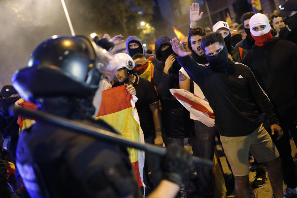 Right wing pro-Spanish unity supporters challenge police officers during a demonstration in Barcelona, Spain, Thursday, Oct. 17, 2019. Catalonia's separatist leader vowed Thursday to hold a new vote to secede from Spain in less than two years as the embattled northeastern region grapples with a wave of violence that has tarnished a movement proud of its peaceful activism. (AP Photo/Bernat Armangue)