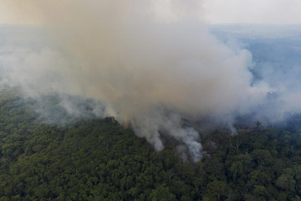 In this Nov. 29, 2019 photo, smoke rises from a fire in the Amazon rainforest near route BR-163 and the Trans-Amazon highway in Ruropolis, Para state, Brazil. Official data show Amazon deforestation rose almost 30% in the 12 months through July, to its worst level in 11 years. Para state alone accounted for 40% of the loss, especially along the Trans-Amazon and BR-163 highways. (AP Photo/Leo Correa)