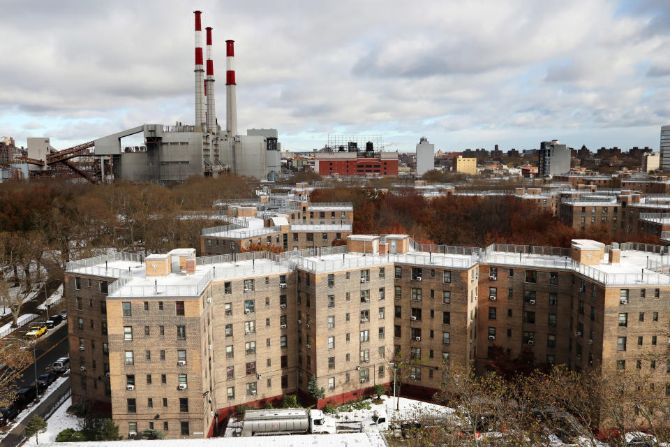 The Queensbridge Houses are located near the Ravenswood Generating Station, upper left, Friday, Nov. 16, 2018, in New York. The largest public housing complex in the country, Queensbridge Houses consists of roughly 6,400 residents in 3,100 apartments across 26 nearly-identical brick buildings. Residents of the New York City public housing complex near the spot where Amazon plans to put a new headquarters have mixed reaction to the global behemoth coming to the neighborhood. (AP Photo/Mark Lennihan)