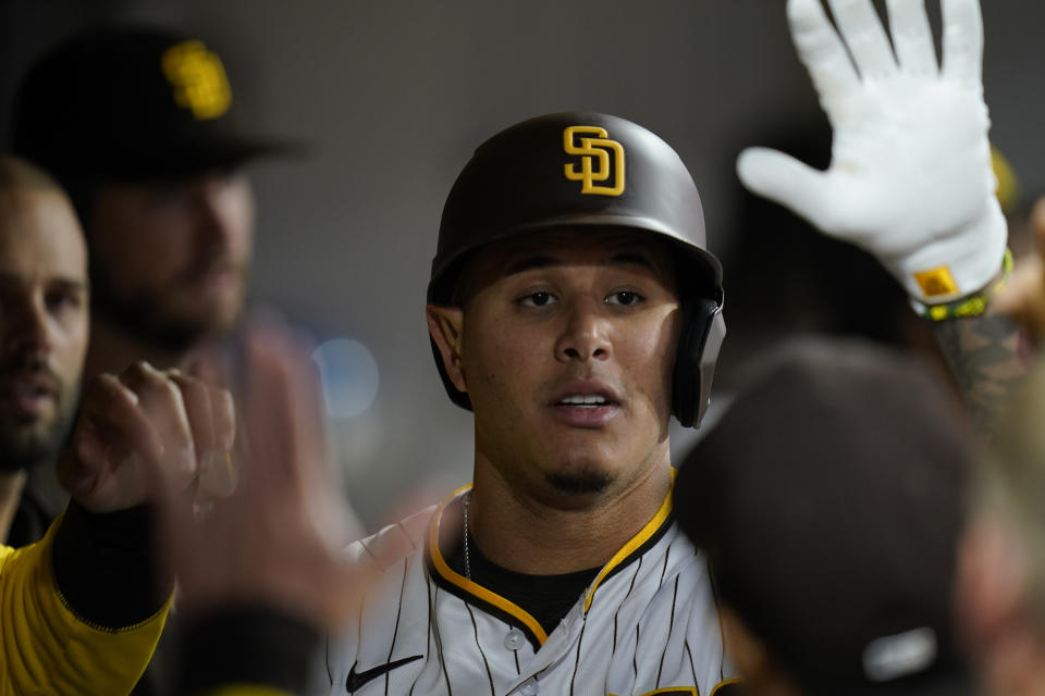 San Diego Padres' Manny Machado, right, is congratulated by teammates after his home run during the fourth inning of the team's baseball game against the Miami Marlins, Thursday, May 5, 2022, in San Diego. (AP Photo/Gregory Bull)