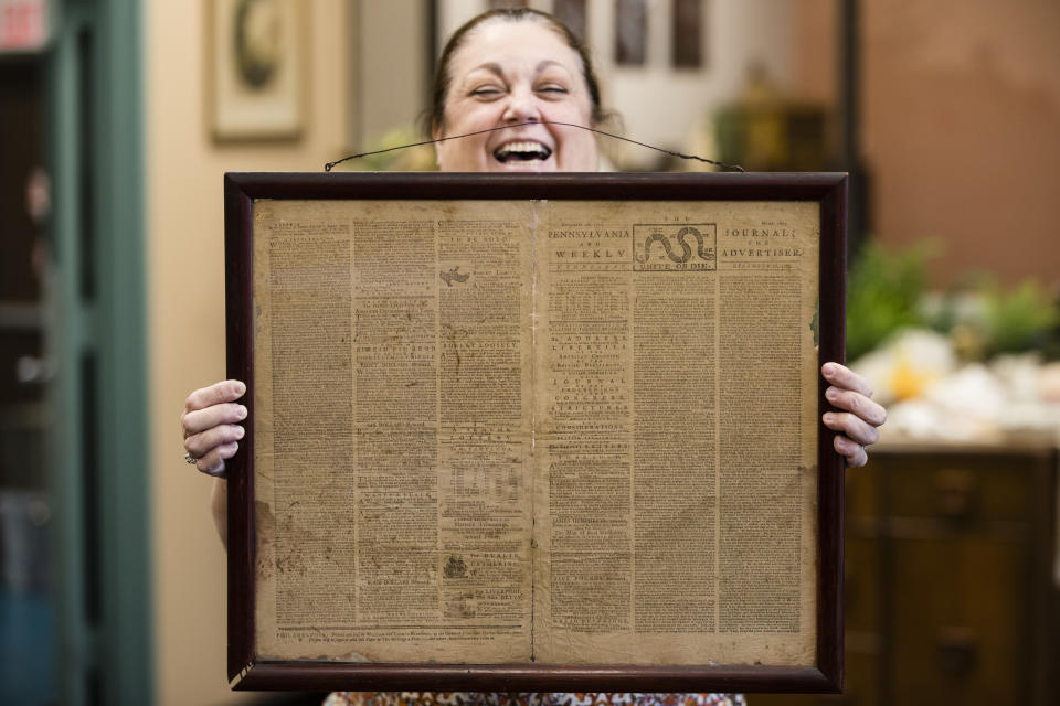 Heather Randall displays a Dec. 28, 1774 Pennsylvania Journal and the Weekly Advertiser at the Goodwill Industries South Jersey in Bellmawr, N.J., Thursday, Oct. 25, 2018. A quick eye by Goodwill workers in southern New Jersey turned up an original 1774 Philadelphia newspaper with an iconic "Unite or Die" masthead. (AP Photo/Matt Rourke)