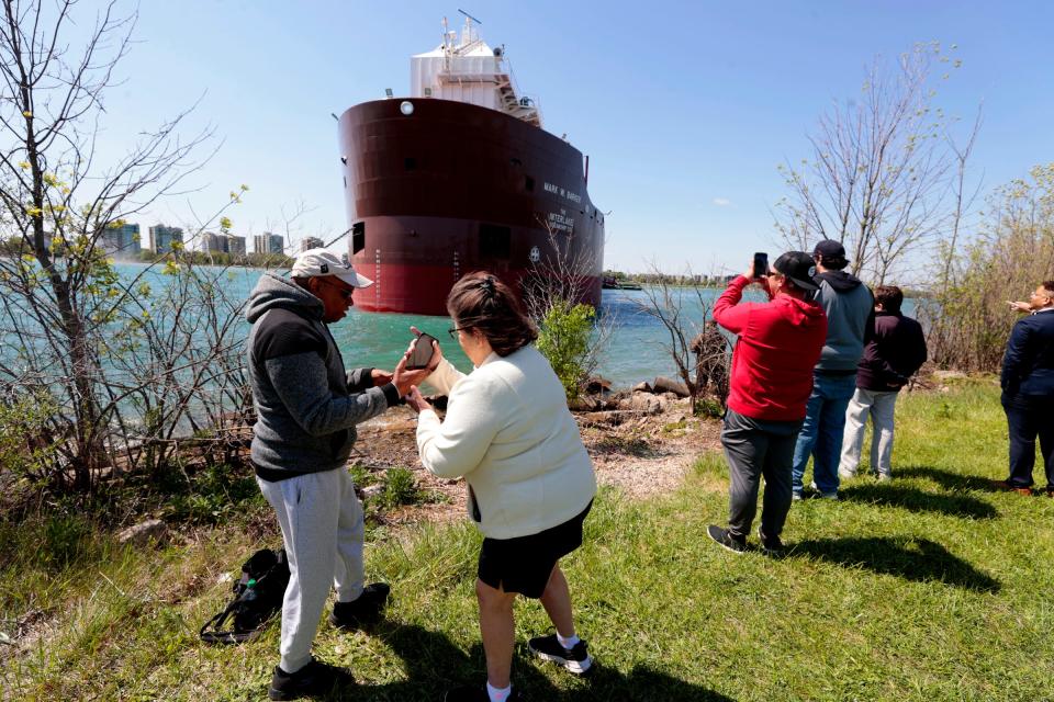 People photograph the Mark W. Barker of the Interlake Steamship Company as it’s so close to the shore on Belle Isle in Detroit after it ran aground on Wednesday morning May 17, 2023.