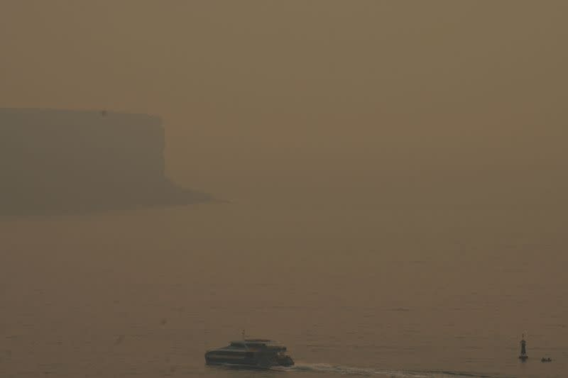 Smoke from bushfires is seen obscuring North Head at Sydney Harbour