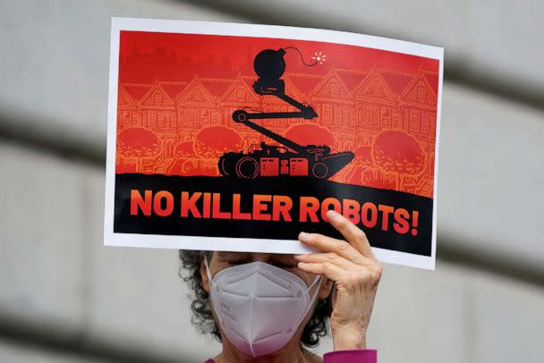 PHOTO: A woman holds up a sign while taking part in a demonstration about the use of robots by the San Francisco Police Department outside of City Hall in San Francisco, on Dec. 5, 2022. (Jeff Chiu/AP)